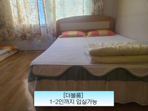a bed in a bedroom with a price sign on it at Sorak Garden Resortel in Sokcho