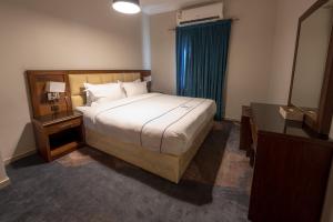 a bedroom with a bed and a dresser and a mirror at جولدن نيو السلامة GOLDEN NEW AlSALAMH in Jeddah +15 photos