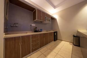 a kitchen with wooden cabinets and a counter top at جولدن نيو السلامة GOLDEN NEW AlSALAMH in Jeddah