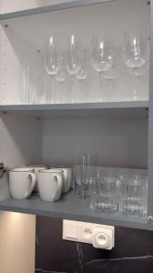 a shelf with wine glasses and bowls on it at AH Residence Anička in KoÅ¡ickÃ© KÃºpele +2 photos