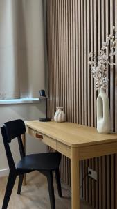 a wooden table with a chair and a vase at AH Residence Anička in KoÅ¡ickÃ© KÃºpele