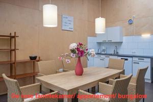 a vase of flowers on a wooden table in a kitchen at opdehoekvandestal in Workum