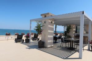 a pergola with a table and chairs and the ocean at Golden Sea View Penthouse in Pomorie