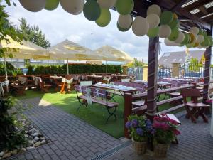 an outdoor patio with tables and chairs and umbrellas at Mattes Restaurant & Pension in Držovice