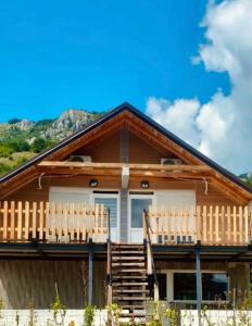 a log home with a deck and mountains in the background at Mountains story in Bistrica Lipovska