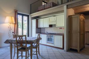 a kitchen with white cabinets and a table and chairs at Hotel Residence Juvarra Centro Benessere in Biella