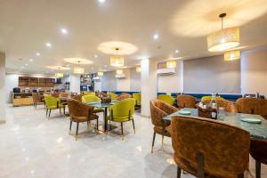 a restaurant with tables and chairs and a cafeteria at Saltstayz Select- Medicity Near Medanta Hospital in Gurgaon
