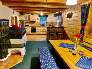 a kitchen with a table and benches in a room at Chata Pod Kohůtkou in Nový Hrozenkov