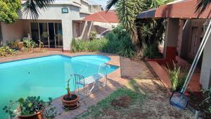 ein Swimmingpool mit einem Stuhl neben einem Haus in der Unterkunft EL Golfview in De Deur