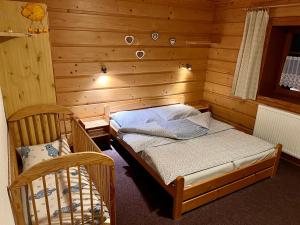 a bedroom with a bed in a wooden room at Chata Pod Kohůtkou in Nový Hrozenkov