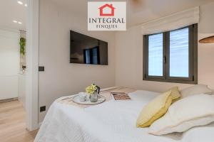 a bedroom with a white bed with a table on it at Apartament Eden Mar in Platja d'Aro +17 photos