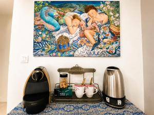 a kitchen counter with a coffee maker and a picture on the wall at Cabris Village Escape - Junior Suite in Cabris