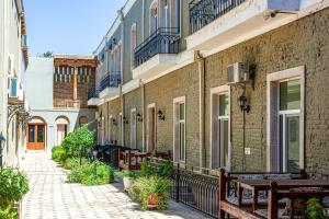 a brick building with benches next to a street at Khan Hotel Bukhara Old Town in Bukhara