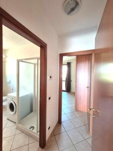 ein Badezimmer mit Spiegel und Waschmaschine in der Unterkunft Mare Maremma in Scarlino