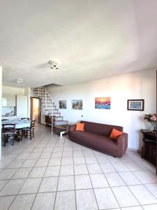 ein Wohnzimmer mit Sofa und ein Esszimmer in der Unterkunft Mare Maremma in Scarlino