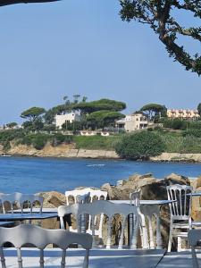 a group of white chairs sitting next to the water at Villa MG Hotel in Santa Marinella