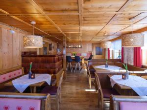a restaurant with wooden walls and tables and chairs at Hotel Alpenblick in Bach