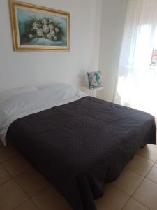 a bed in a bedroom with a picture on the wall at Ippocampo in Giardini Naxos
