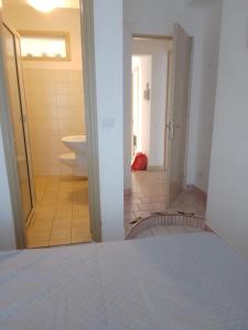 a bathroom with a door open to a room with a toilet at Ippocampo in Giardini Naxos +6 photos