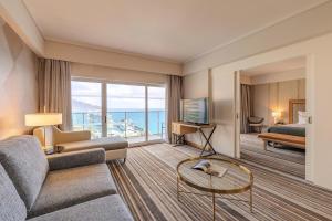 a living room with a couch and a television at Pestana Carlton Madeira Ocean Resort Hotel in Funchal