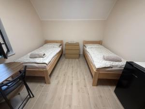 two beds in a room with a table and a desk at Ubytování U Dědečka in Lomnice nad Lužnicí