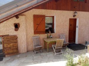 a patio with a table and chairs on a house at Chambres d'hôtes 05 Crévoux in Crévoux