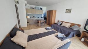a small room with two beds and a kitchen at Beach View Apartment Chernomorec in Chernomorets