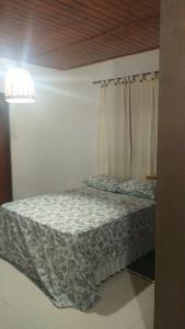a bedroom with a bed and a window with a bedspread at Chalé Caminho Real in Itamonte +36 photos