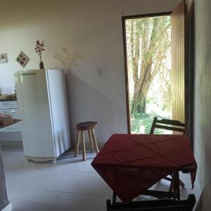 a kitchen with a refrigerator and a table and chairs at Chalé Caminho Real in Itamonte