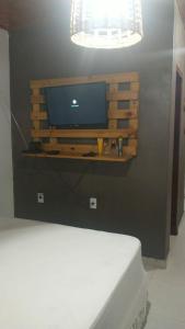 a computer monitor on a shelf on a wall at Chalé Caminho Real in Itamonte