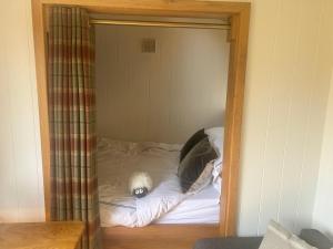 a small bed in a small room with at Astwell Mill Luxury Shepherds Hut in Helmdon