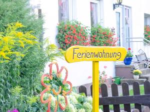 a yellow sign in a garden with flowers at Ferienwohnung Hertel in Mistelgau +33 photos