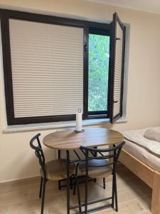 a table and chairs in a room with a window at Ubytování U Dědečka in Lomnice nad Lužnicí