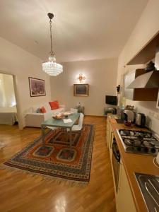 a kitchen and living room with a table and a couch at Exclusive Aparthotel La Reunion in Ravenna
