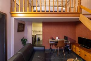 a living room with a couch and a table with a laptop at Hotel INGREDI in Bree