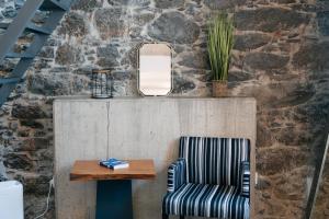 a chair and a table and a mirror at Casa do Sol by Amazing Madeira in Jardim do Mar