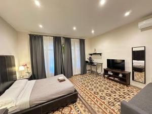 a bedroom with a large bed and a flat screen tv at Rooms Balmes in Barcelona