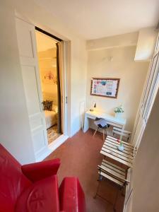 a living room with a red couch and a desk at Rooms Balmes in Barcelona