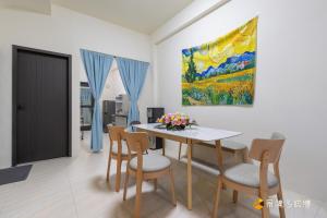 a dining room with a table and chairs and a painting at 玉里步道民宿 in Yuli