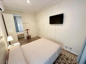a bedroom with a bed and a flat screen tv at Rooms Balmes in Barcelona