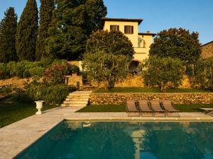 a villa with a swimming pool in front of a house at Podere di Montecchio in Florence