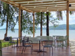 a table and chairs on a deck with a view of the water at Mrs. Swan Hotel in Ban Hin Chang (2)