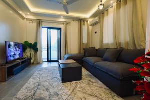 a living room with a couch and a tv at Nile Kingdom Guest house in Luxor