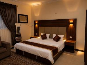 a hotel room with a large bed and a couch at شركة العييري للشقق المخدومة شركة شخص واحد الاحساء 2 in Al Ahsa