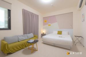 a bedroom with a bed and a couch in a room at 玉里步道民宿 in Yuli