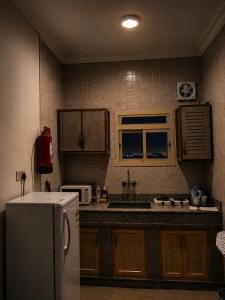 a kitchen with a refrigerator and a sink at شركة العييري للشقق المخدومة شركة شخص واحد الاحساء 2 in Al Ahsa