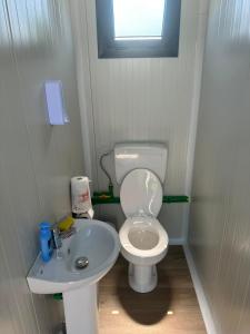 a small bathroom with a toilet and a sink at LakeSide Camping in Koplik
