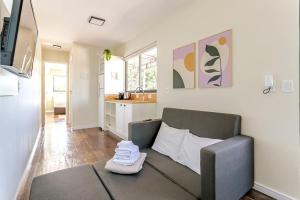 a living room with a couch and a kitchen at SPA-AC-BBQ-Casa Container-Cozinha Completa in Florianópolis
