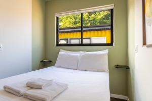 a bedroom with a white bed with a window at SPA-AC-BBQ-Casa Container-Cozinha Completa in Florianópolis +38 photos