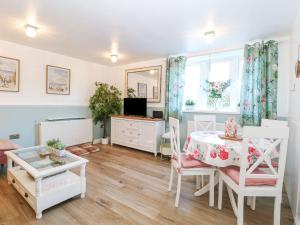 a living room with a table and a mirror at Hideaway Cottage in Hunstanton